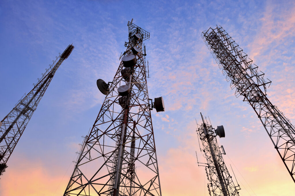 Imagem fotográfica de quatro torres de telecomunicação.